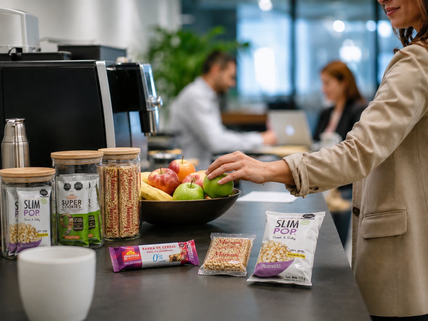 Persona tomando fruta junto a una estación de snacks en oficina
